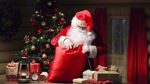 santa-claus-packing-gift-boxes-in-sack-and-waving-hand_vk-7tcpgm__m0000